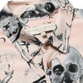 Close up photo of Blinky Bills Shirt No. 2 collar on white back ground. Very light pink short-sleeved shirt with print of different tattoo designs in greyscale.